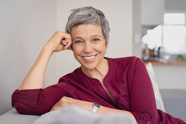 Mature woman smiling on a couch.