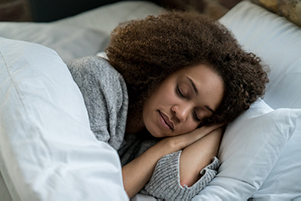 Woman peacefully sleeping in bed.