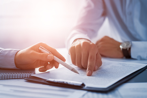 Close up of doctor's and patient's hands reviewing paperwork, in Happy Valley, OR.