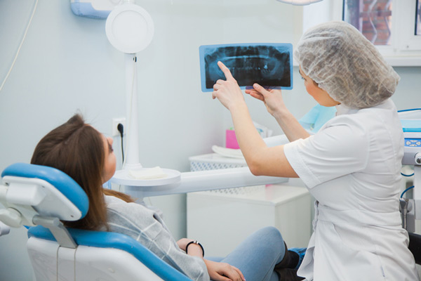 A woman reviewing her x-ray with a dentist, at Fusion Dental Specialists in Happy Valley, OR.