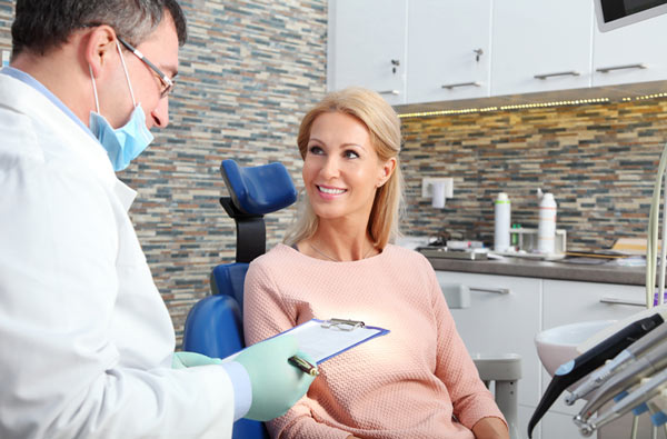 Woman talking to dentist during dental exam.
