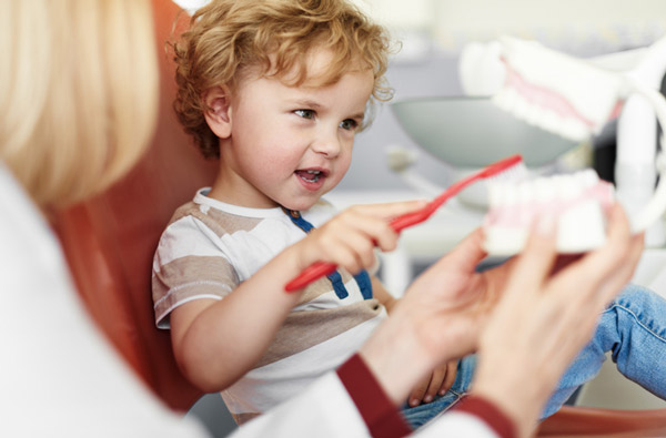 Little boy learning to brush teeth, at Fusion Dental Specialists in Happy Valley, OR.