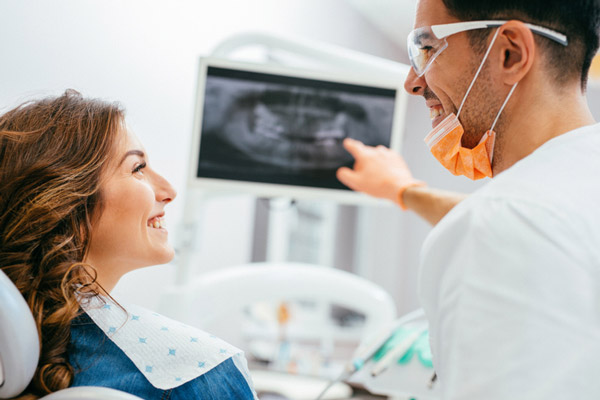 Dentist explaining an x-ray to a woman patient, at Fusion Dental Specialists in Happy Valley, OR.